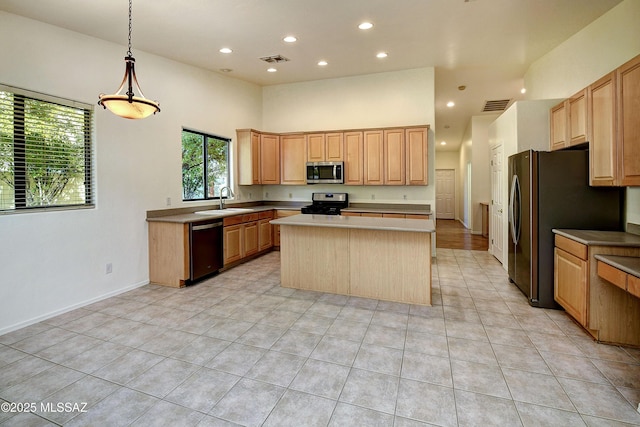 kitchen featuring appliances with stainless steel finishes, sink, decorative light fixtures, a high ceiling, and a kitchen island