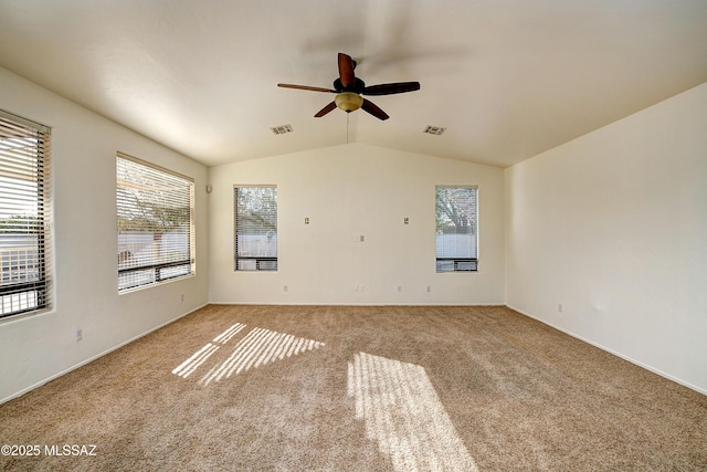 carpeted spare room featuring ceiling fan and vaulted ceiling