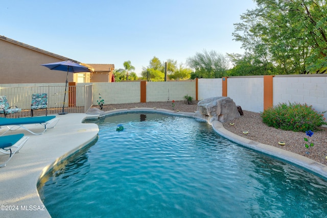 view of swimming pool featuring pool water feature and a patio