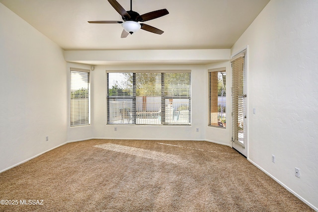 carpeted spare room featuring a wealth of natural light and ceiling fan