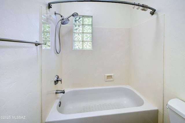 bathroom with toilet and washtub / shower combination