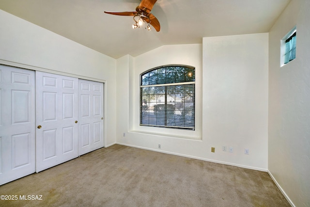 unfurnished bedroom with light carpet, a closet, ceiling fan, and lofted ceiling