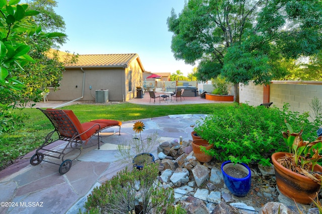 view of yard with central AC and a patio area