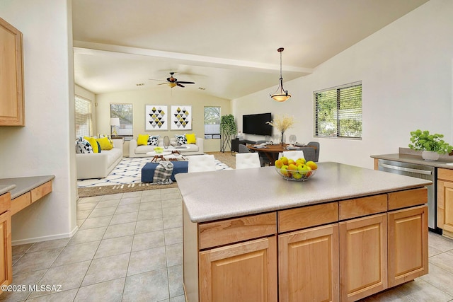 kitchen featuring ceiling fan, stainless steel dishwasher, pendant lighting, vaulted ceiling, and a kitchen island