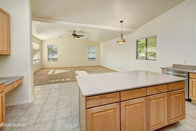 kitchen featuring pendant lighting, stainless steel dishwasher, vaulted ceiling with beams, ceiling fan, and a kitchen island