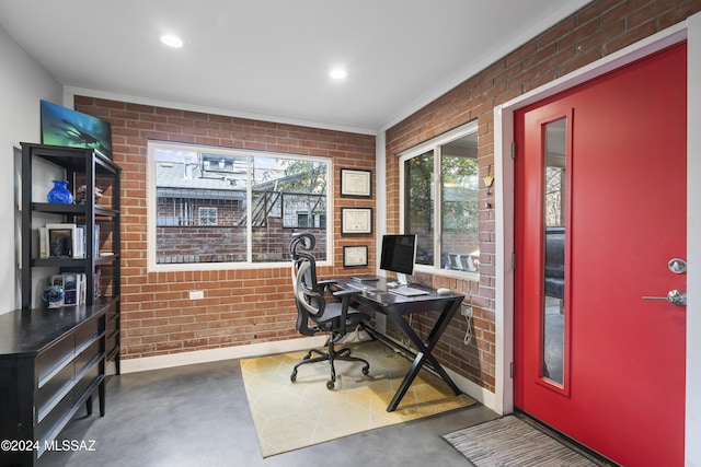 home office featuring a wealth of natural light and brick wall