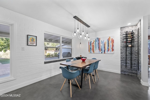 dining area with plenty of natural light and brick wall