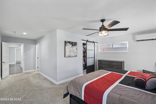 carpeted bedroom featuring a wall mounted AC, ceiling fan, and a barn door