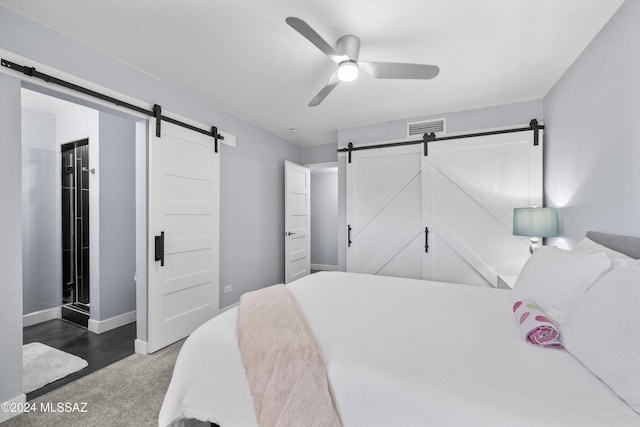 bedroom featuring ceiling fan and a barn door