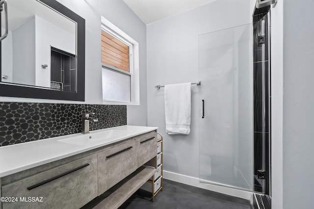 bathroom featuring decorative backsplash, vanity, and a shower with shower door