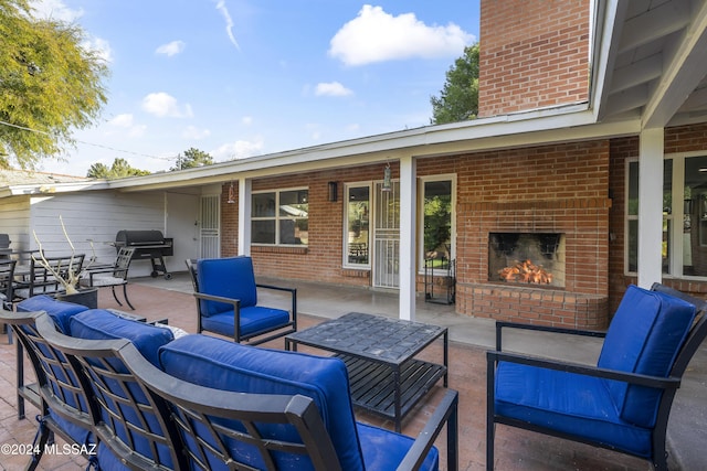 view of patio featuring an outdoor living space with a fireplace and area for grilling