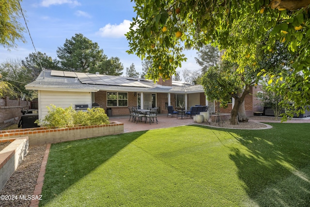 rear view of property with solar panels, a patio, and a yard