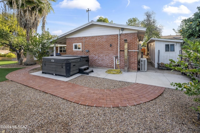 back of house featuring a patio and a hot tub