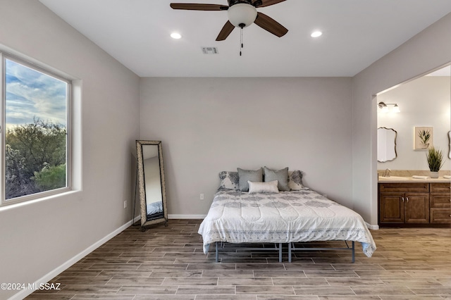 bedroom with ensuite bath, ceiling fan, and light hardwood / wood-style floors