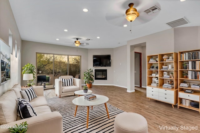 living room featuring ceiling fan and light hardwood / wood-style floors