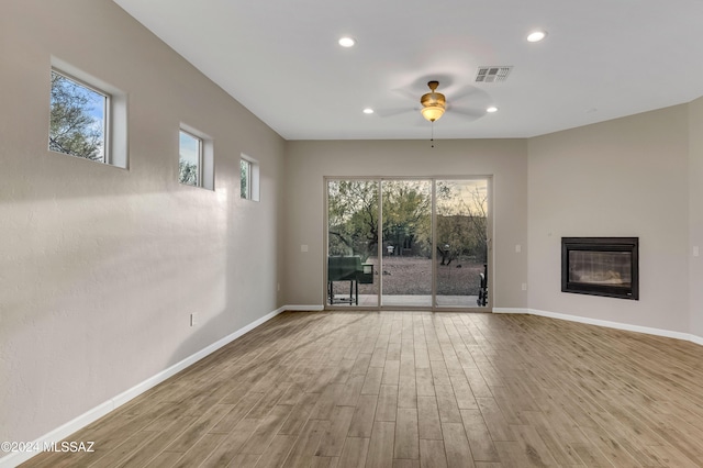 unfurnished living room with ceiling fan, light hardwood / wood-style floors, and a wealth of natural light