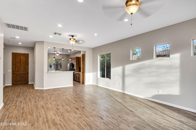 unfurnished living room with ceiling fan and hardwood / wood-style flooring