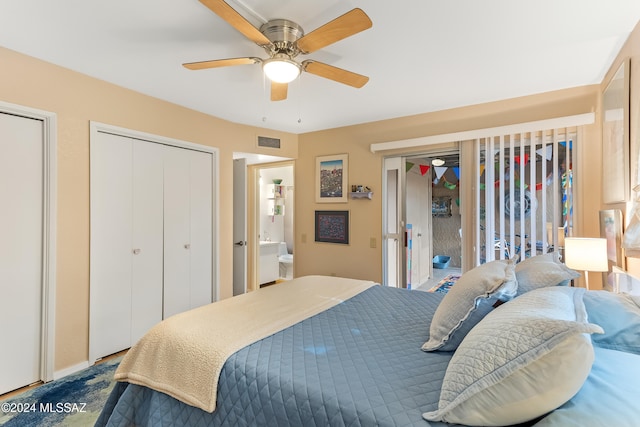 bedroom with ceiling fan, ensuite bathroom, and two closets