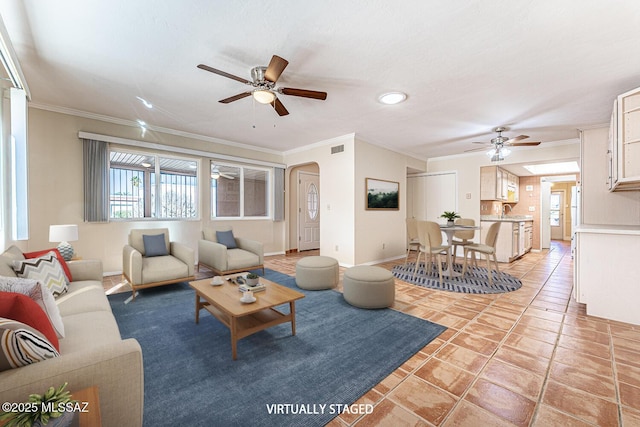 tiled living room with ceiling fan, ornamental molding, and sink