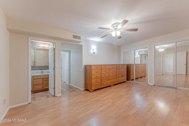 unfurnished bedroom featuring ensuite bathroom, ceiling fan, light hardwood / wood-style floors, and sink