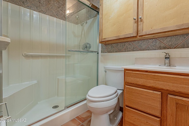 bathroom with backsplash, vanity, tile patterned flooring, toilet, and a shower with shower door