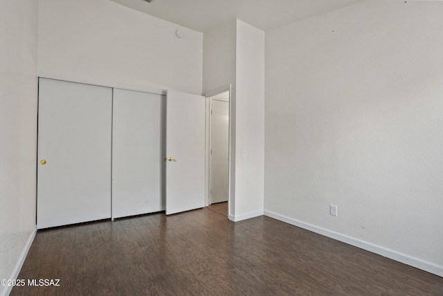 unfurnished bedroom featuring dark hardwood / wood-style floors and a closet