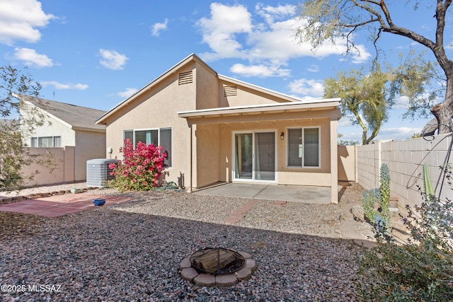 rear view of property with a patio area, a fire pit, and central air condition unit