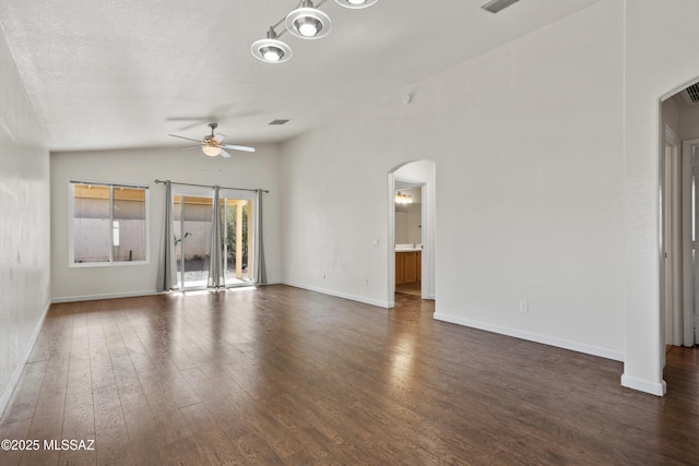 unfurnished living room featuring a textured ceiling, vaulted ceiling, dark hardwood / wood-style floors, and ceiling fan