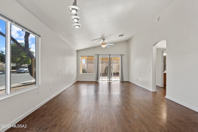 unfurnished living room featuring ceiling fan, dark hardwood / wood-style floors, and vaulted ceiling