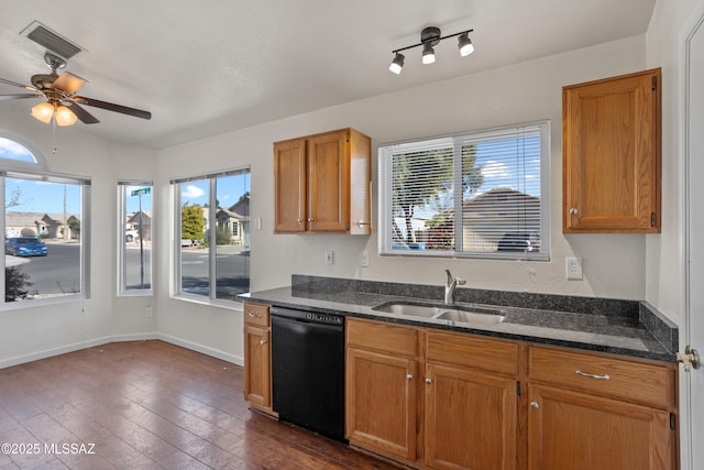 kitchen with dark hardwood / wood-style flooring, black dishwasher, sink, and dark stone countertops