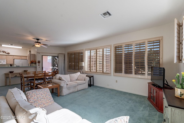 carpeted living room with ceiling fan and a healthy amount of sunlight