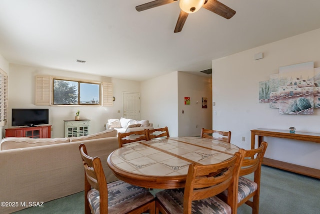 dining space with ceiling fan and carpet floors