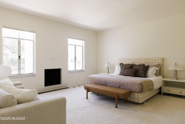 bedroom featuring light colored carpet and multiple windows