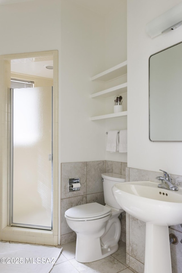 bathroom featuring walk in shower, sink, tile walls, tile patterned flooring, and toilet