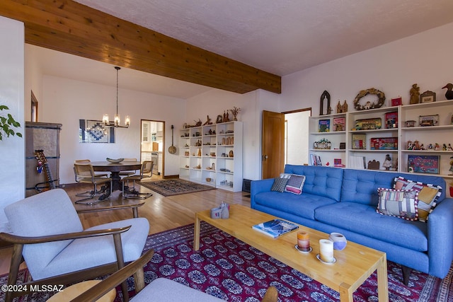 living room featuring beam ceiling, hardwood / wood-style floors, and an inviting chandelier