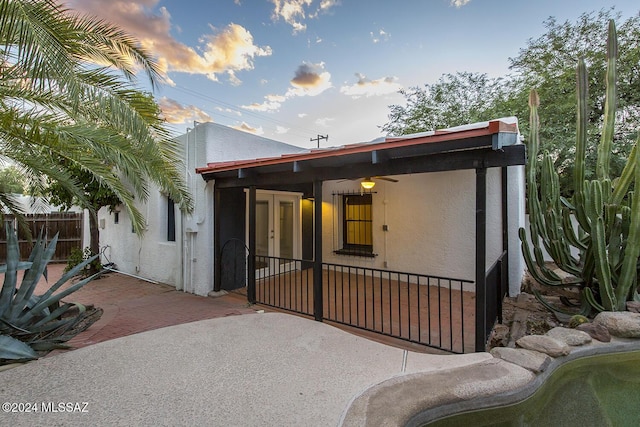 back house at dusk featuring a patio area