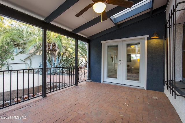 unfurnished sunroom with ceiling fan, french doors, and lofted ceiling with beams