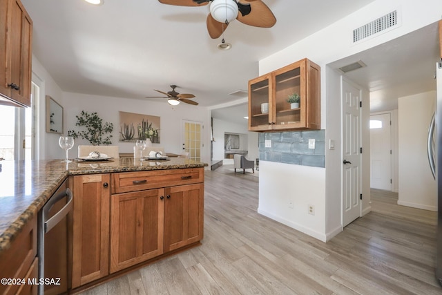 kitchen featuring french doors, light wood-type flooring, stainless steel dishwasher, dark stone counters, and ceiling fan