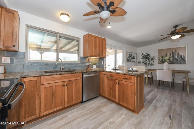 kitchen featuring sink, light hardwood / wood-style flooring, kitchen peninsula, decorative backsplash, and appliances with stainless steel finishes