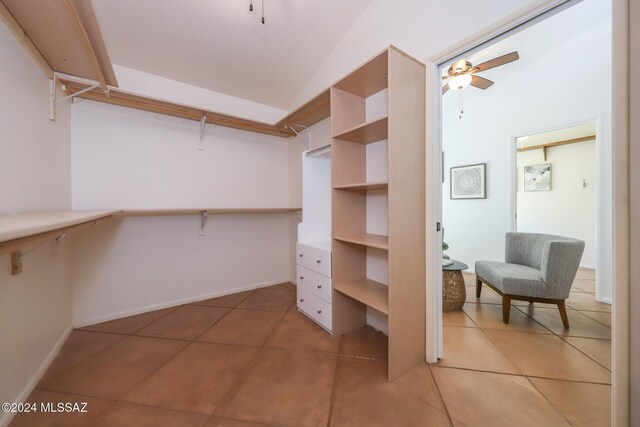 spacious closet with light tile patterned floors, ceiling fan, and lofted ceiling