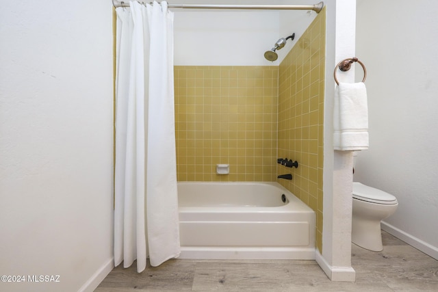 bathroom featuring shower / bath combo, hardwood / wood-style flooring, and toilet