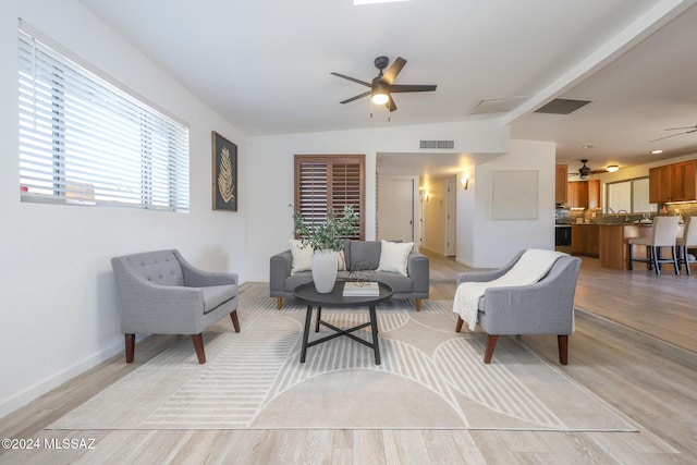 living room with plenty of natural light, ceiling fan, light wood-type flooring, and lofted ceiling