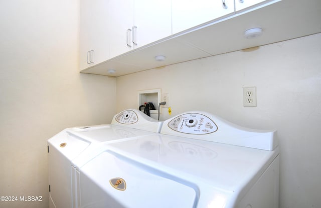 washroom with washer and clothes dryer and cabinets