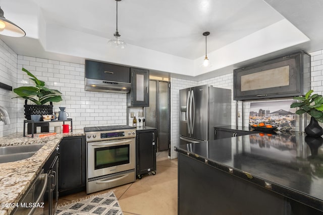 kitchen with decorative light fixtures, sink, stainless steel appliances, and tasteful backsplash