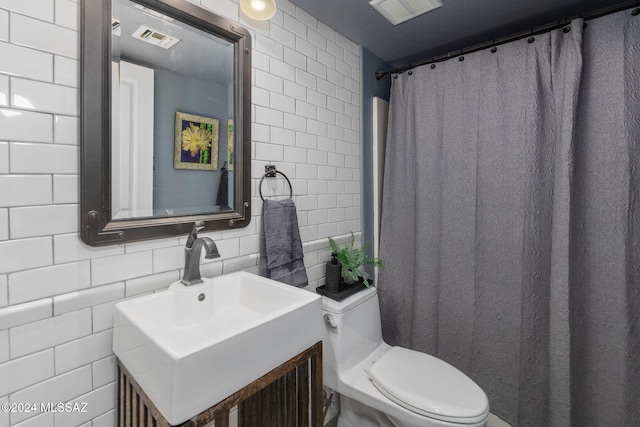 bathroom featuring backsplash, vanity, tile walls, and toilet