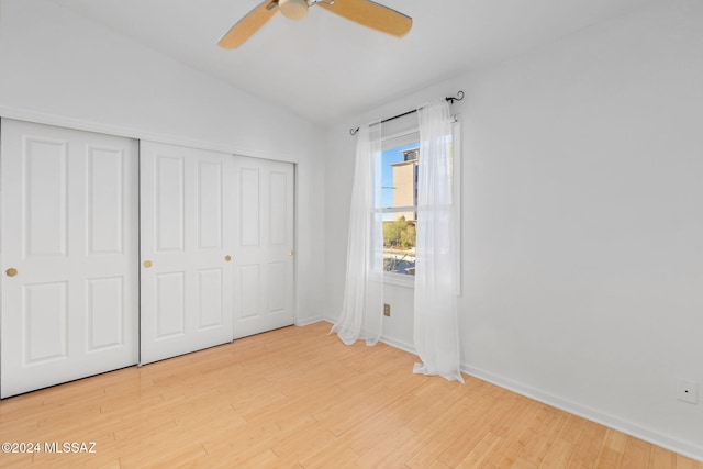 unfurnished bedroom featuring hardwood / wood-style flooring, a closet, lofted ceiling, and ceiling fan