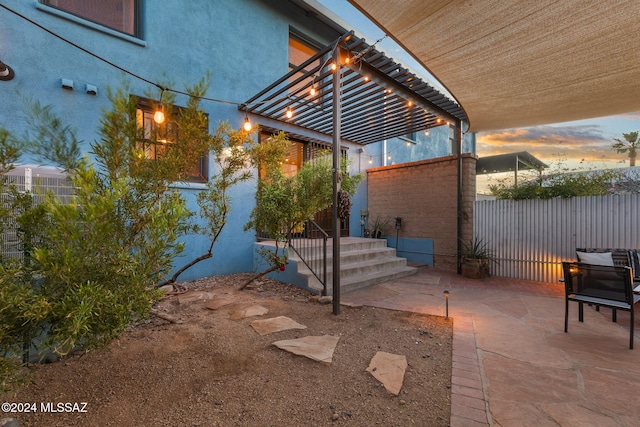 patio terrace at dusk featuring a pergola