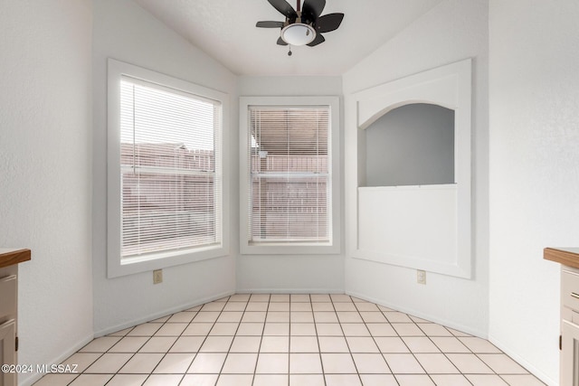 unfurnished dining area featuring ceiling fan, light tile patterned flooring, and lofted ceiling