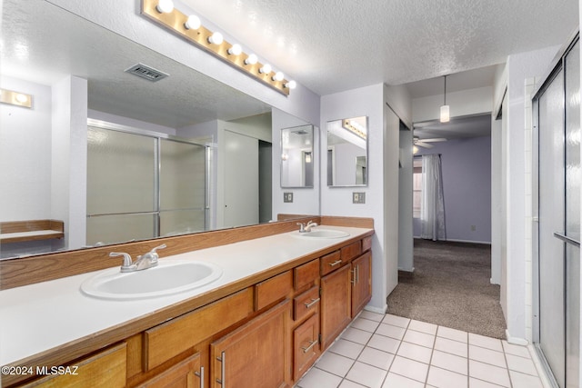 bathroom featuring tile patterned floors, ceiling fan, vanity, and a textured ceiling