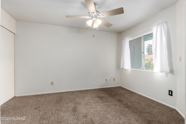 carpeted spare room featuring ceiling fan